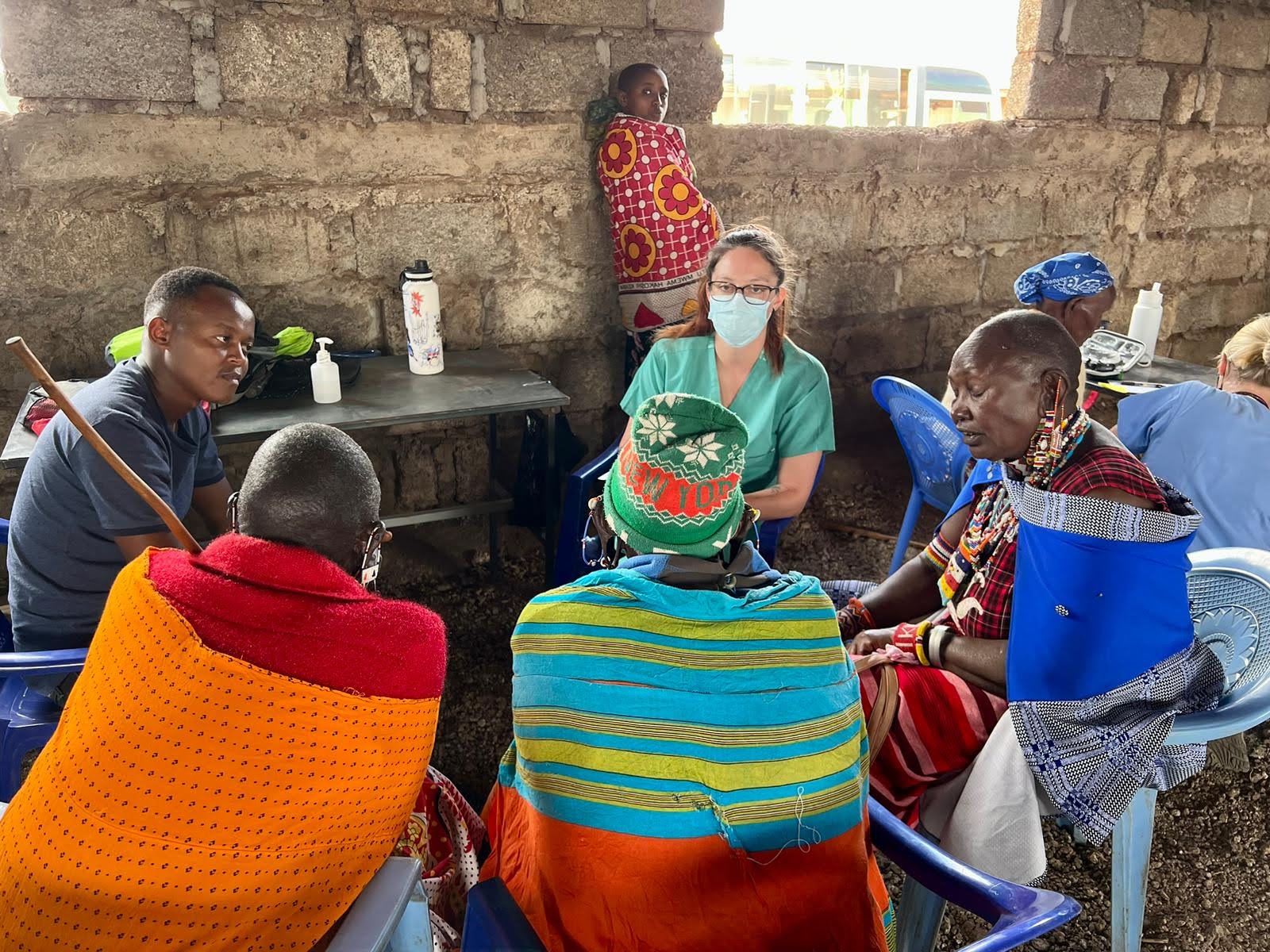 A health worker attending to seated community members during an outreach